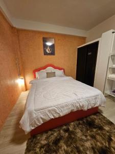 a bedroom with a large bed with a red headboard at Hommie by De-A-Ga in Ban Bang Talat