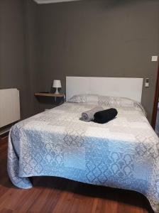 a bed with a blanket and a hat on it at Habitación3 Villena lavanda in Villena