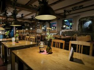 a restaurant with wooden tables and chairs and lights at Wirtshaus am Treidelpfad in Haßmersheim
