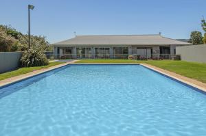 a large blue swimming pool in front of a house at The Blue Cabin in Fisherhaven