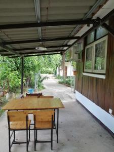 una mesa de madera y un banco frente a un edificio en Wasuthan Garden House en Nong Khai