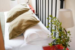 a bed with two pillows and a table with a plant at Hotel Rural El Zaguán in Lerma