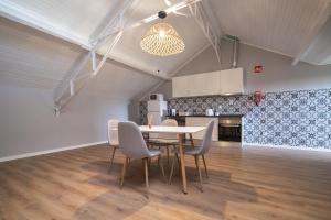 a kitchen and dining room with a table and chairs at D'Ávila Peixinho 180 in Aveiro