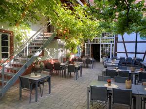 a restaurant with tables and chairs and a staircase at Wirtshaus am Treidelpfad in Haßmersheim
