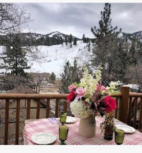 una mesa con un mantel con flores en el balcón en 004 - Bearadise, en Big Bear Lake