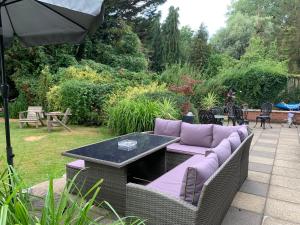 a couch with a table and an umbrella at Broadwalk8 in Coltishall