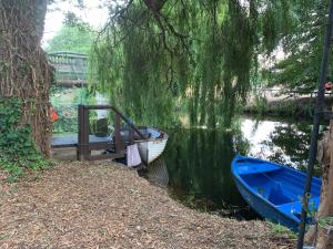 a boat is docked next to a dock on a river at Broadwalk8 in Coltishall
