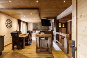 a dining room with a table and chairs and a television at Superbe logement, jacuzzi extérieur, vue, sauna in Champagny-en-Vanoise