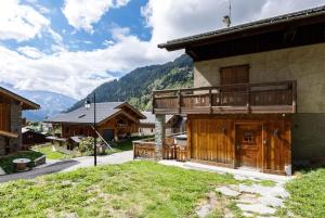a house with a balcony on the side of it at Superbe logement, jacuzzi extérieur, vue, sauna in Champagny-en-Vanoise