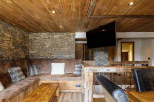 a living room with a couch and a flat screen tv at Superbe logement, jacuzzi extérieur, vue, sauna in Champagny-en-Vanoise