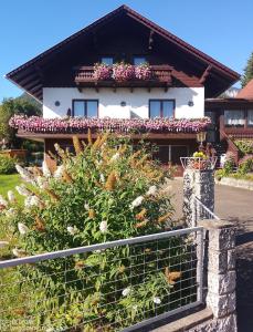 ein Haus mit Blumen vor einem Zaun in der Unterkunft Haus Bergblick in Oberort