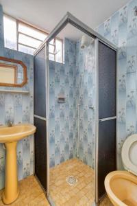 uma casa de banho com um chuveiro e um lavatório. em Itajubá Classic Hotel Goiânia em Goiânia