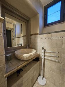 a bathroom with a sink and a mirror and a toilet at Doremisia in Tarquinia
