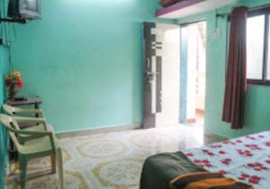 ein Schlafzimmer mit einem Bett und einem Stuhl in einem Zimmer in der Unterkunft Serina House Malvan in Malvan