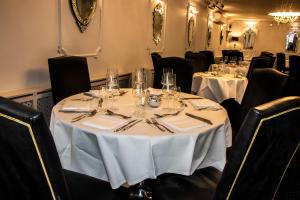 a dining room with a table with white table cloth and chairs at The Lord Bute in Highcliffe