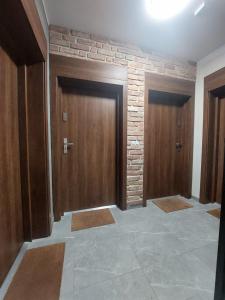a hallway with two doors and a stone wall at Apartamenty Jaskółcza in Bydgoszcz