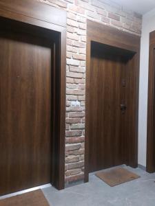 two doors in a room with a brick wall at Apartamenty Jaskółcza in Bydgoszcz