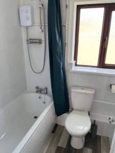 SeaCross Sheringham Norfolk Coast 3 Bed Detached house في شيرينغهام: حمام مع مرحاض وحوض استحمام ومغسلة
