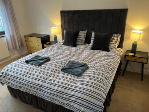 a bedroom with a large bed with two pillows on it at SeaCross Sheringham Norfolk Coast 3 Bed Detached house in Sheringham