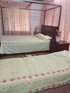 a bedroom with two beds and a mirror at Pournami Home Stay in Trichūr