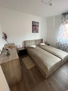 - une chambre avec un grand lit et du parquet dans l'établissement Ajrin Apartman Kopaonik, à Kopaonik
