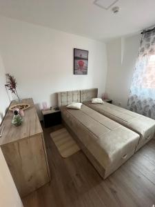 a bedroom with a large bed and a wooden floor at Ajrin Apartman Kopaonik in Kopaonik