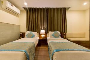 una camera d'albergo con due letti e una finestra di OPO Hotel Viva Palace a Nuova Delhi