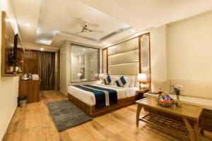 una camera d'albergo con letto e tavolo di OPO Hotel Viva Palace a Nuova Delhi