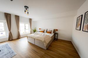 Highlight am Stadtplatz Mühldorf - Come4Stay - 2 Zimmer Wohnung I bis zu 4 Gäste في مولدورف: غرفة نوم بيضاء بسرير ونوافذ