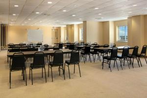 a conference room with tables and chairs and a whiteboard at Microtel Inn & Suites by Wyndham Quincy Downtown - River Area in Quincy