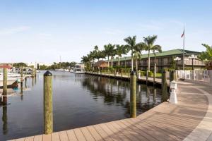 einen Yachthafen mit Palmen und einem Gebäude in der Unterkunft Ramada by Wyndham Sarasota Waterfront in Sarasota