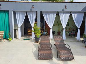 eine Terrasse mit Stühlen und einem Baldachin mit weißen Vorhängen in der Unterkunft Apartamento CondominioEuropa centro de barra mansa in Barra Mansa