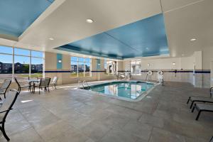 uma piscina num quarto com cadeiras e uma mesa em Hilton Garden Inn Omaha East/Council Bluffs em Council Bluffs