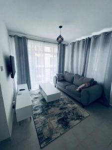 a living room with a couch and a table at One Bedrooms & Studios at Ngong Rd in Nairobi