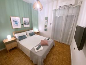 a bedroom with a bed and a flat screen tv at MediTerra Stay in the heart of Athens in Athens