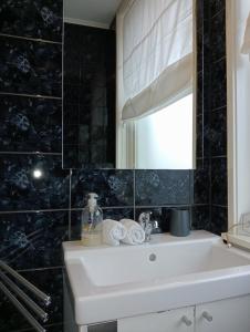 La salle de bains est pourvue d'un lavabo blanc et d'un miroir. dans l'établissement Studio Slijterij Zandvoort, à Zandvoort