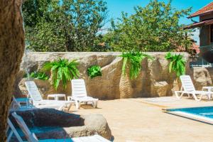 - un groupe de chaises assises à côté de la piscine dans l'établissement Guesthouse The Rock, à Sapareva Banya