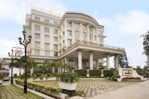 un grande edificio bianco con molte piante di Ramada Plaza By Wyndham, Chandigarh Zirakpur a Chandīgarh