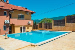 a swimming pool in front of a house at Guesthouse The Rock in Sapareva Banya