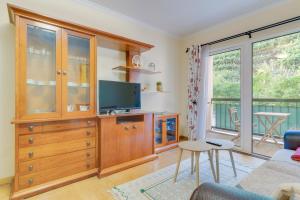 a living room with a tv and a entertainment center at Isabel Apartment by Holiday Rental Madeira in Ribeira Brava