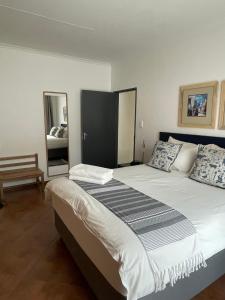 a bedroom with a large bed and a mirror at City comfort self catering Windhoek in Windhoek