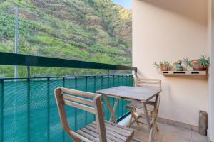 a table and chairs on a balcony with a view at Isabel Apartment by Holiday Rental Madeira in Ribeira Brava