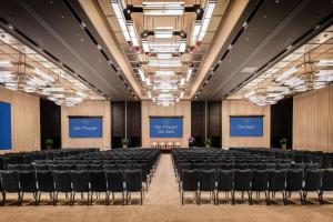 una sala conferenze con sedie e schermi di Conrad Guangzhou a Canton