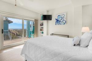 - une chambre blanche avec un grand lit et un balcon dans l'établissement Portside Villas unit 17 - Beach Life, à Pensacola Beach