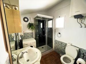 a bathroom with a toilet and a sink and a shower at Casa de la Luz in Cuevas del Campo