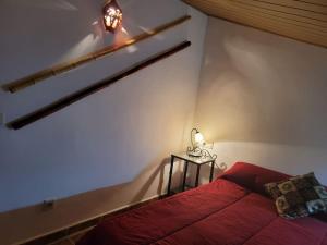 a bedroom with a red bed and a side table at Casa de la Luz in Cuevas del Campo