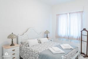 ein Schlafzimmer mit einem weißen Bett mit zwei Lampen in der Unterkunft Casa da Praia - Santa Cruz center in Santa Cruz