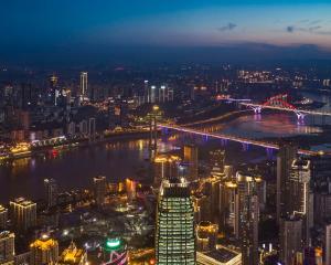 een uitzicht op een stad 's nachts met een brug bij The Lixury Hotel, in The Unbound Collection by Hyatt in Chongqing