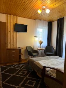 a hotel room with a bed and a desk and chairs at Ніч над Карпатами in Slavske