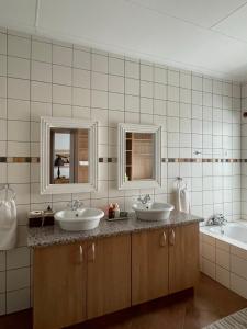 a bathroom with two sinks and two mirrors at City comfort self catering Windhoek in Windhoek